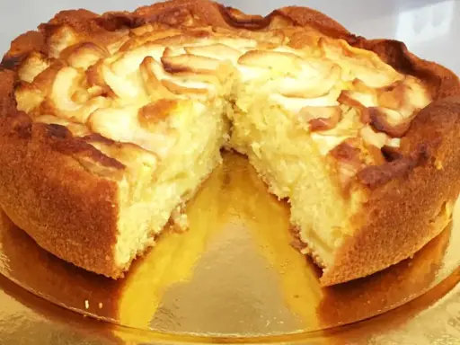 Una deliziosa torta di mele, dorata e soffice, con fette di mela disposte a spirale sulla superficie.