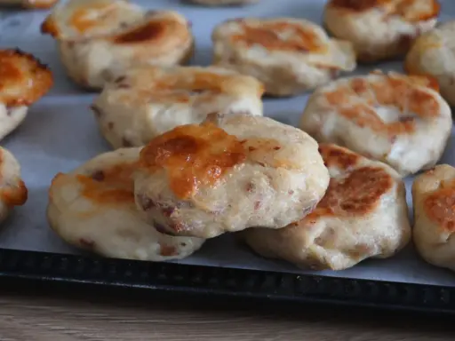 Deliziose polpette di pollo appena sfornate, dorate e con formaggio filante, pronte per essere gustate.
