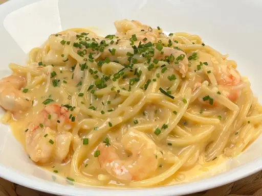 Spaghetti cremosi con gamberi e erba cipollina, una deliziosa carbonara di mare.