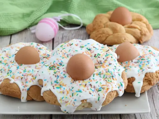 Scarcelle fatte in casa da Benedetta, decorate con glassa bianca, zuccherini colorati e uova sode, pronte per la Pasqua.