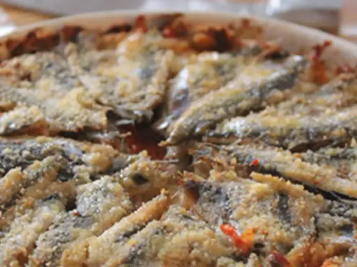 Tortino di alici cotto al forno, con panatura dorata e ingredienti saporiti.