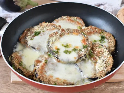 Melanzane in padella con pangrattato e formaggio filante, un piatto gustoso e facile da preparare.