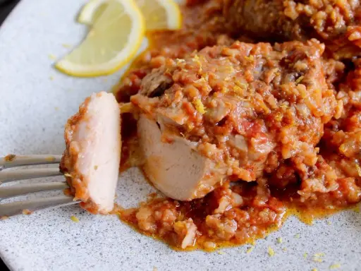 Un saporito ossobuco di tacchino in umido con pomodoro e riso, guarnito con scorza di limone e spicchi freschi.