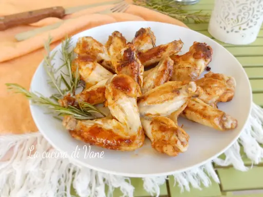 Alette di pollo in padella, dorate e succulente, guarnite con rosmarino fresco. Un piatto semplice e gustoso.