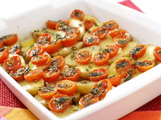 Pomodori gratinati al forno con patate, un piatto semplice e gustoso, pronto per essere infornato.