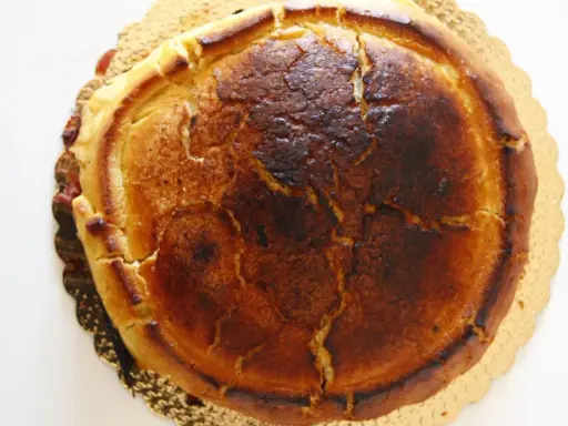 Crostata ricotta e visciole dorata e leggermente bruciacchiata, con un ripieno invitante che traspare dai bordi.