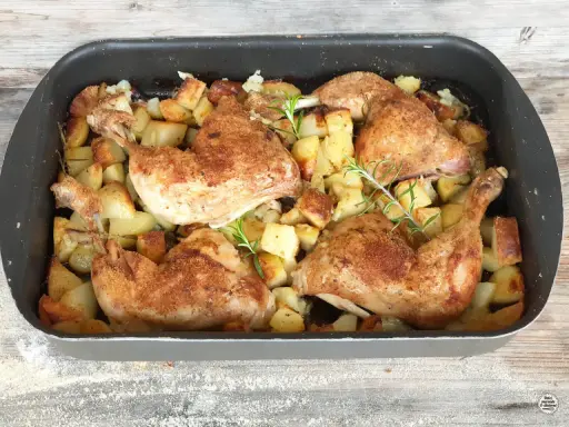 Succulento pollo al forno con patate dorate e rosmarino, pronto per essere gustato.