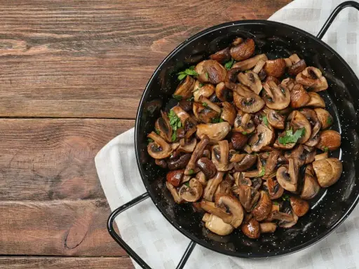 Funghi in padella, dorati e profumati, pronti per essere gustati.