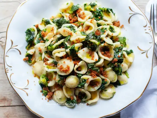 Orecchiette cime di rapa fumanti, condite con olio e mollica tostata, un classico piatto pugliese.