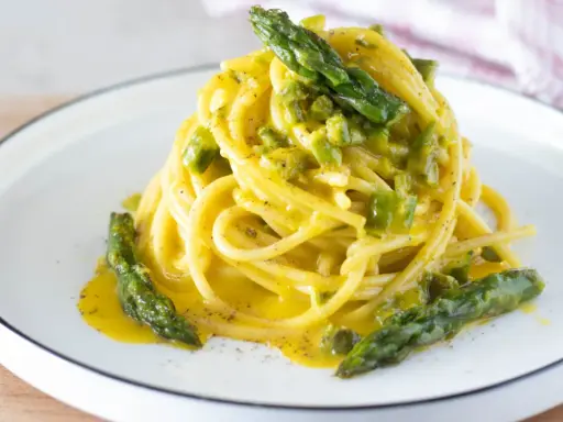 Spaghetti cremosi con asparagi, una deliziosa carbonara di asparagi, guarnita con punte verdi croccanti.
