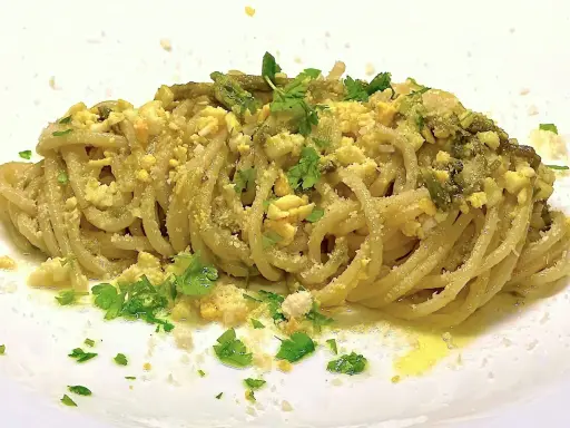 Un piatto di spaghetti con asparagi selvatici, uova sbriciolate e prezzemolo fresco. Un sapore di primavera in ogni boccone.