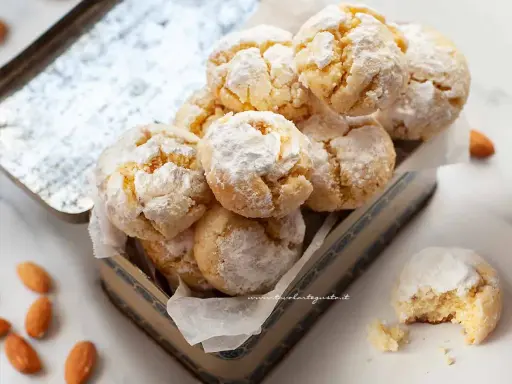 Biscotti con farina di mandorle, soffici e profumati, cosparsi di zucchero a velo, pronti per essere gustati.