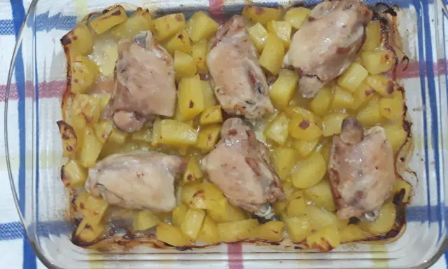 Sovracosce di pollo al forno con patate dorate, un piatto succulento e profumato, pronto per essere gustato.