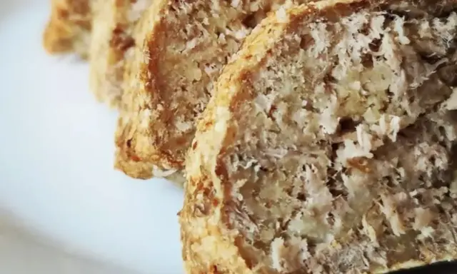 Fette di polpettone di tonno, cotto al forno, con una crosticina dorata e un interno morbido e sfilacciato.