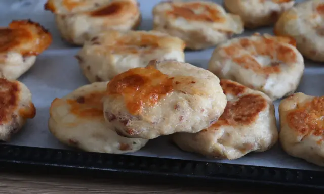 Deliziose polpette di pollo appena sfornate, dorate e con formaggio filante, pronte per essere gustate.