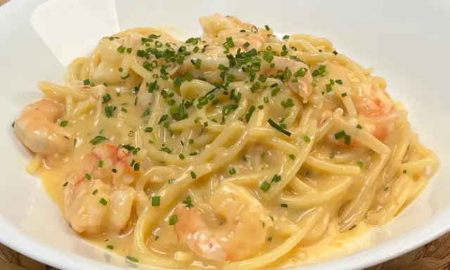 Spaghetti cremosi con gamberi e erba cipollina, una deliziosa carbonara di mare.