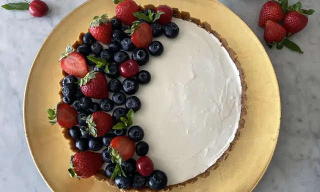 Crostata di frutta fresca con fragole, mirtilli e ciliegie su una base dorata.