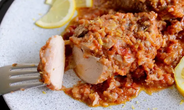 Un saporito ossobuco di tacchino in umido con pomodoro e riso, guarnito con scorza di limone e spicchi freschi.