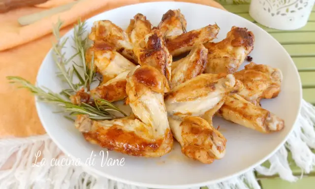 Alette di pollo in padella, dorate e succulente, guarnite con rosmarino fresco. Un piatto semplice e gustoso.