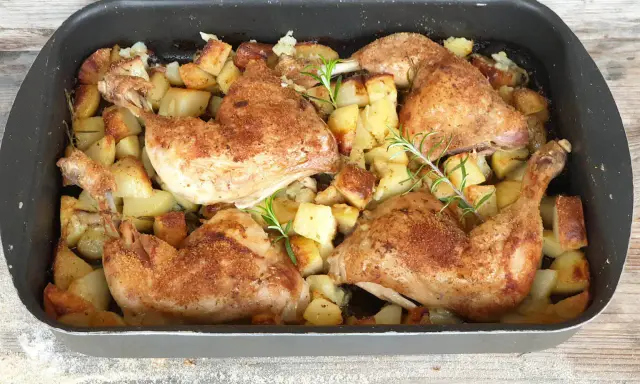 Succulento pollo al forno con patate dorate e rosmarino, pronto per essere gustato.
