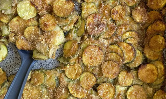 Fette di zucchine al forno dorate e croccanti, condite con parmigiano e pangrattato. Un contorno delizioso e facile da preparare.