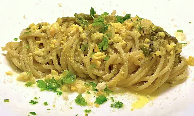Un piatto di spaghetti con asparagi selvatici, uova sbriciolate e prezzemolo fresco. Un sapore di primavera in ogni boccone.