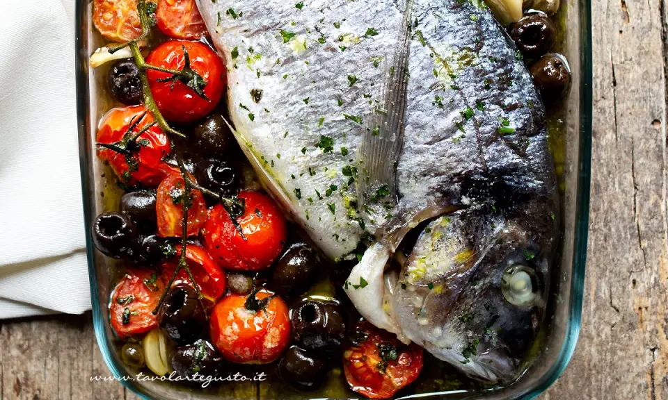 Orata al forno con pomodorini e olive nere, un piatto saporito e profumato, pronto per essere gustato.