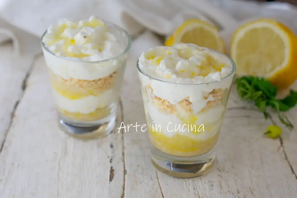 Delizioso tiramis&ugrave; al limone a strati in bicchieri, con crema soffice, biscotti sbriciolati e una spolverata di scorza di limone.