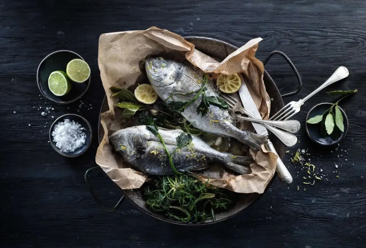 Orata al forno, profumata al limone e erbe aromatiche, pronta per essere gustata.