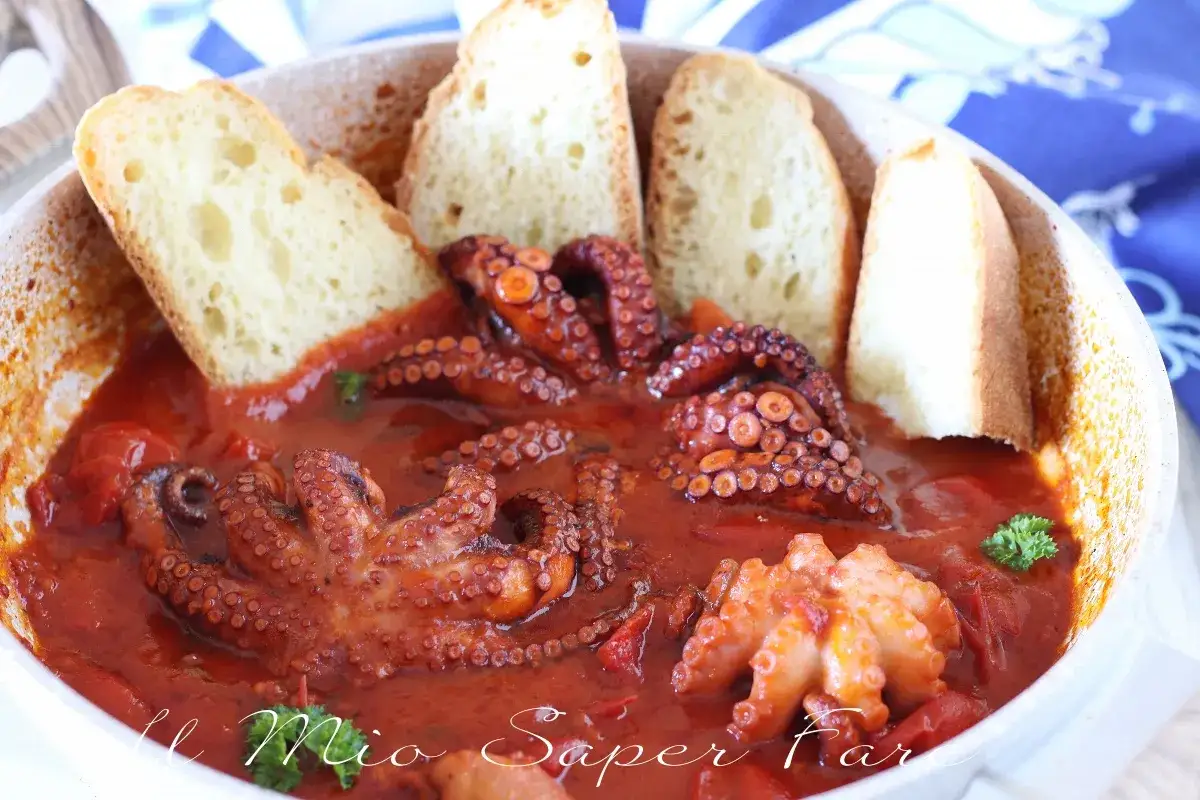 Polipetti in purgatorio, un piatto succulento con tentacoli rossi che sembrano danzare in un sugo di pomodoro, accompagnati da fette di pane tostato.