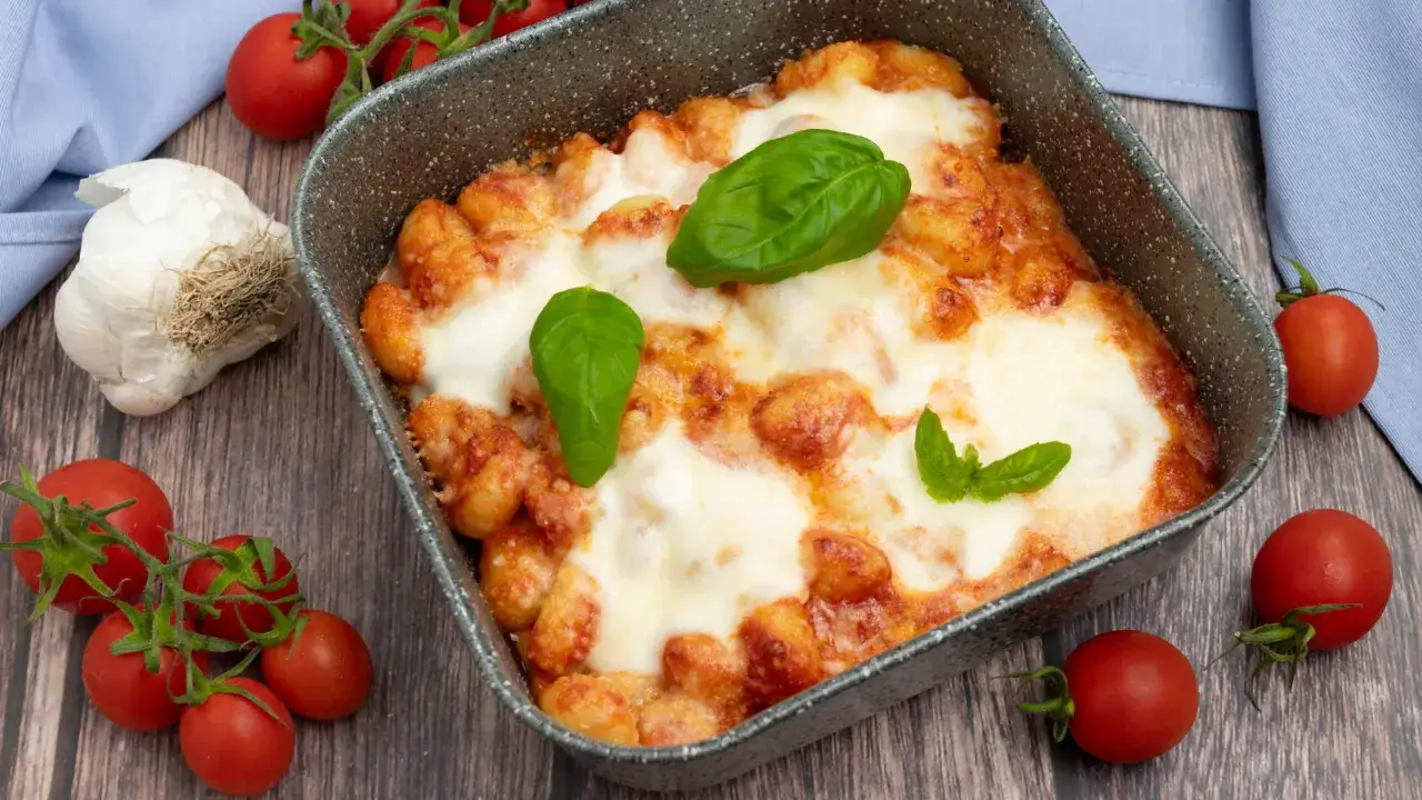 Gnocchi alla sorrentina appena sfornati, filanti e dorati, con pomodoro fresco e basilico.