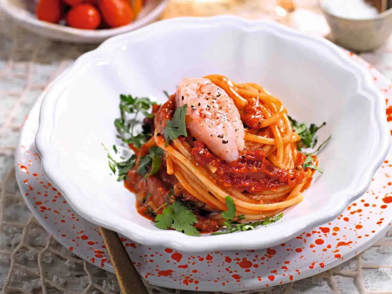 Spaghetti al sugo rosso con un gamberetto rosa in cima, guarniti con prezzemolo fresco. Un piatto invitante di pasta con gamberetti.