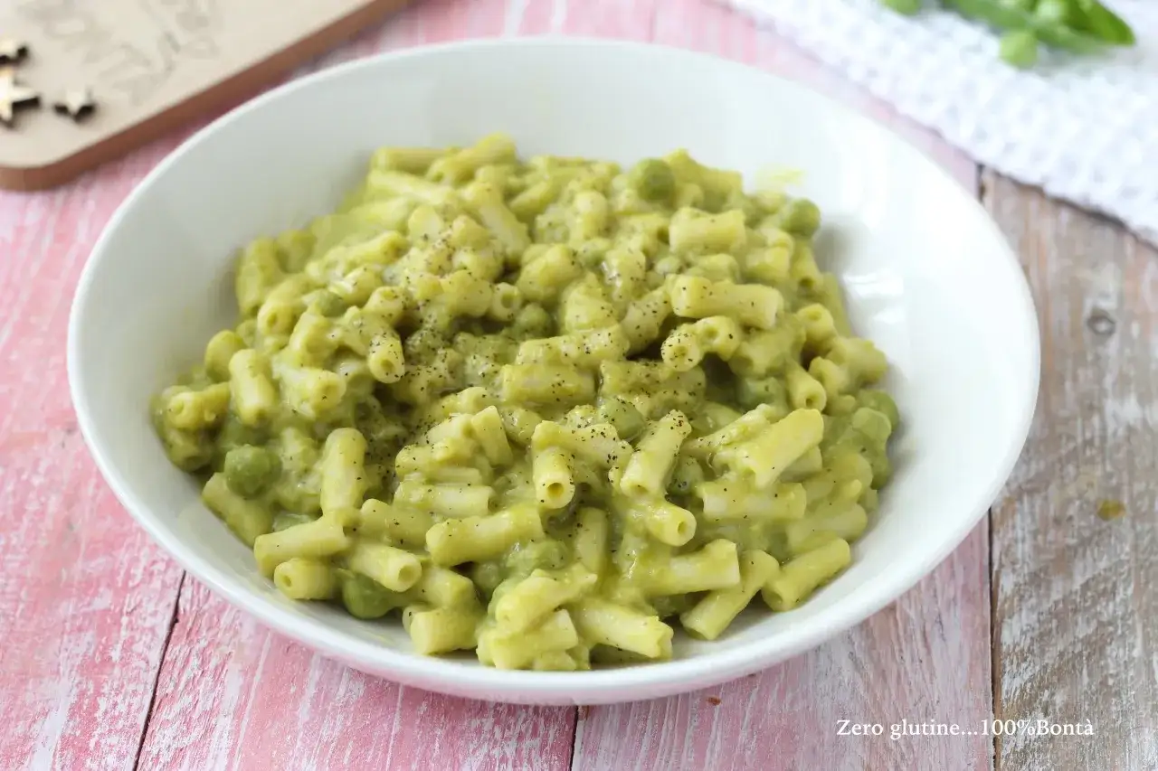 Un piatto cremoso di pasta e piselli, condito con pepe nero macinato fresco.