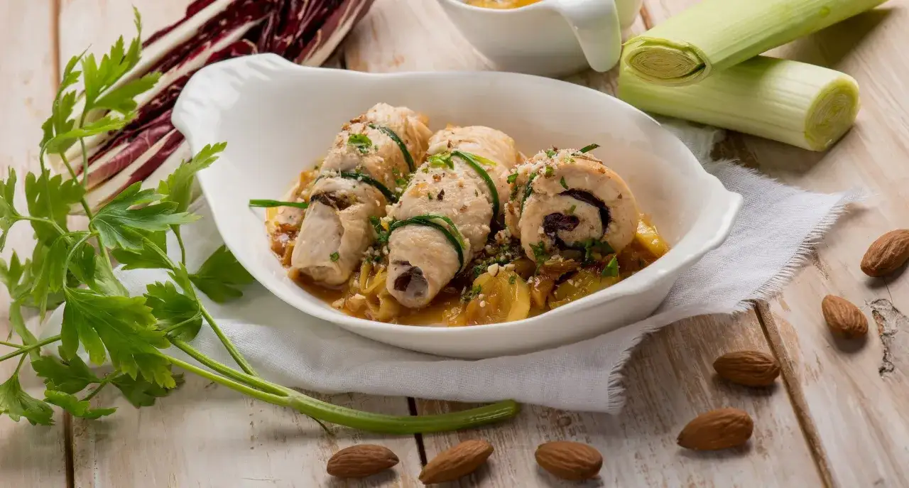 Involtini di pollo ripieni, un modo diverso per gustare il petto di pollo, serviti con verdure e mandorle tostate.