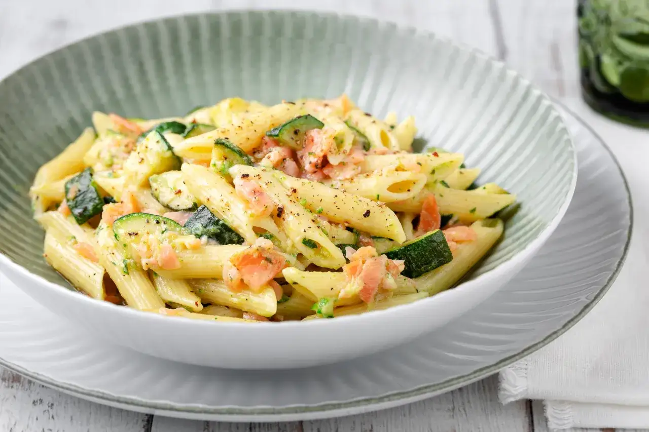 Penne con salmone e zucchine, un piatto cremoso e saporito, condito con erbe aromatiche e pepe nero.