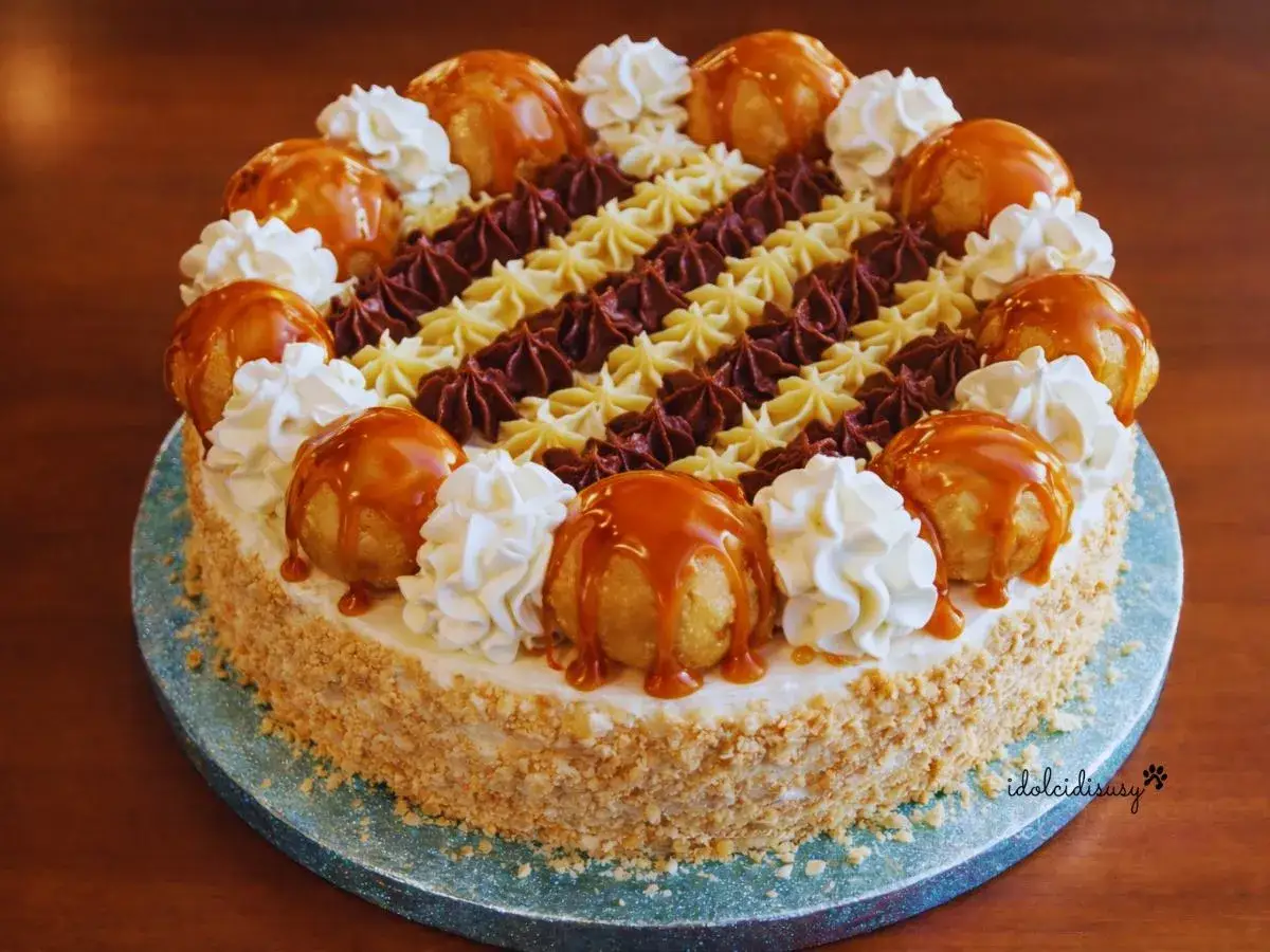 Una magnifica torta Saint Honor&eacute;, decorata con bign&egrave; caramellati, panna montata e riccioli di cioccolato e crema.