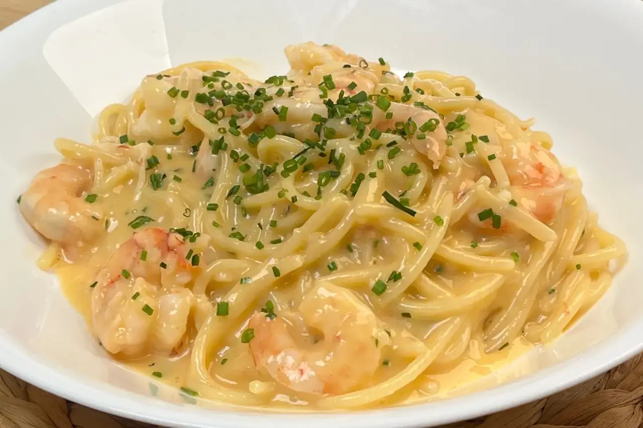 Spaghetti cremosi con gamberi e erba cipollina, una deliziosa carbonara di mare.