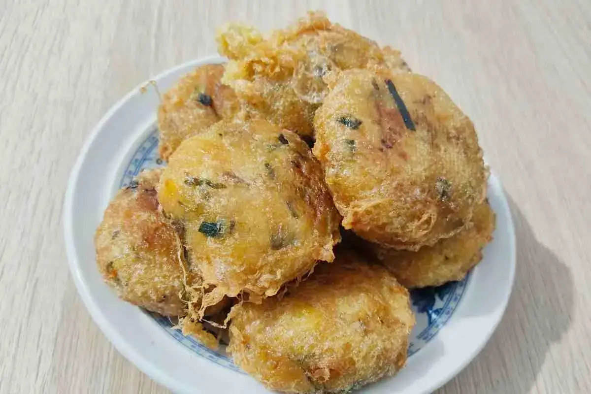 Piatto di rosti di zucchine dorati e croccanti, con pezzetti verdi visibili nell'impasto.