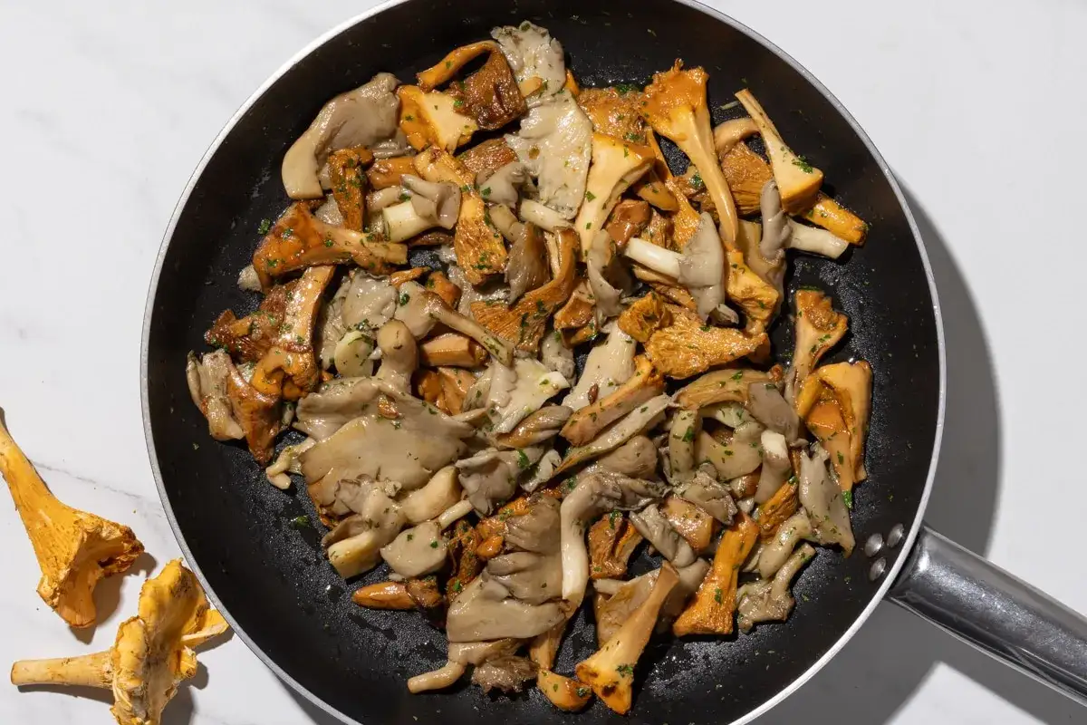 Un misto di funghi freschi, tra cui finferli dorati e funghi ostrica, saltati in padella con erbe aromatiche.