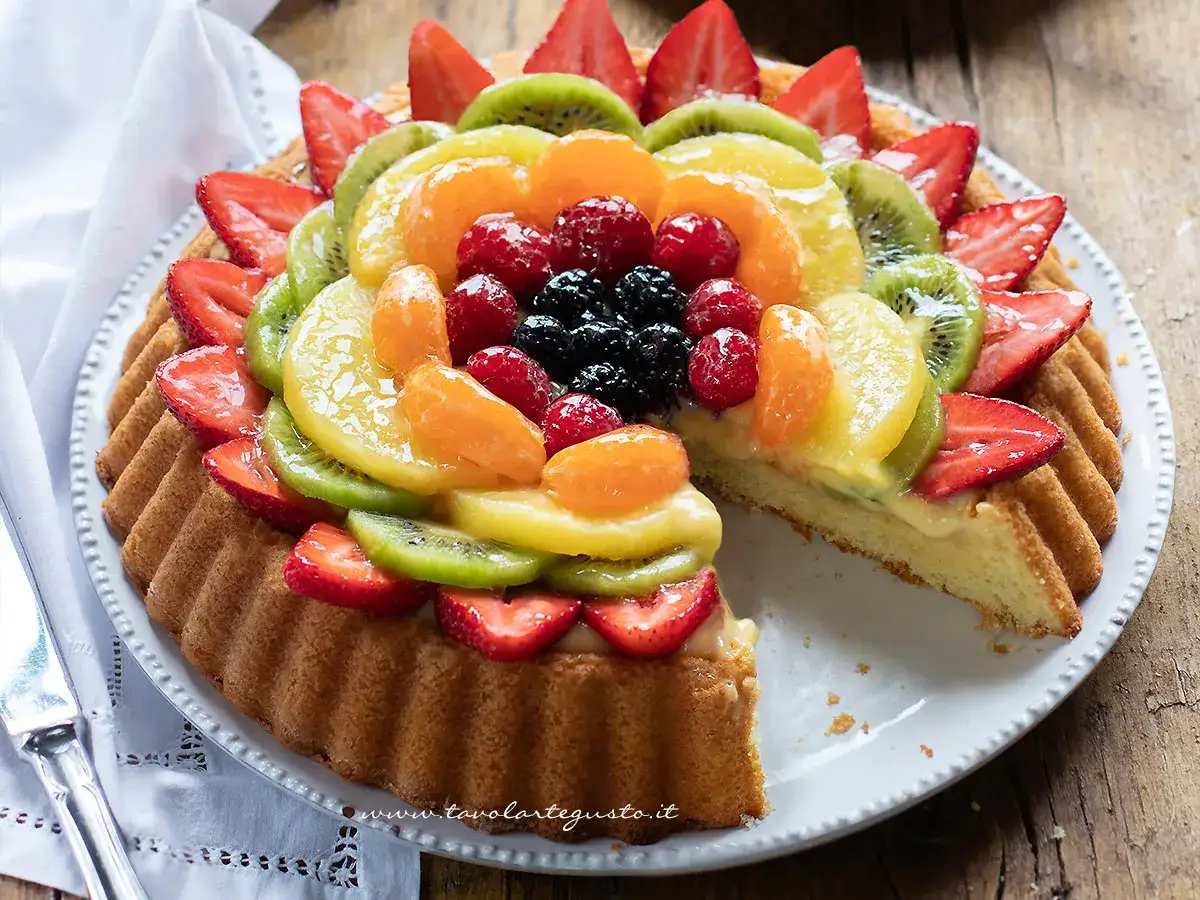 Una deliziosa crostata di frutta, con fragole, kiwi, mandarini, lamponi e more, guarnita con crema pasticcera.