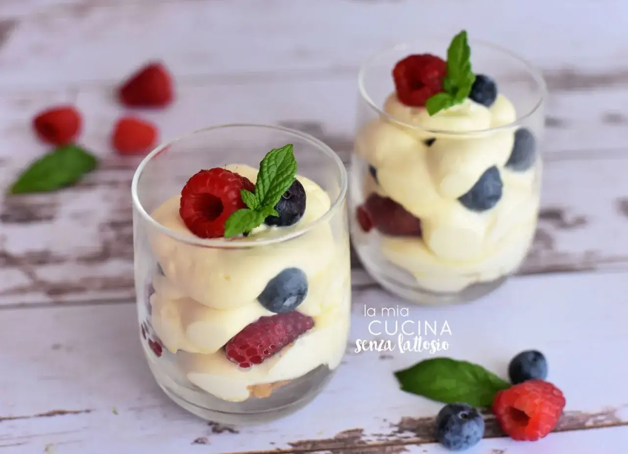 Deliziosa crema al mascarpone con frutti di bosco e menta, servita in bicchieri trasparenti.