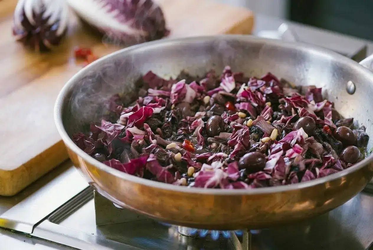 Radicchio in padella con olive e pinoli, un contorno saporito che profuma di casa.