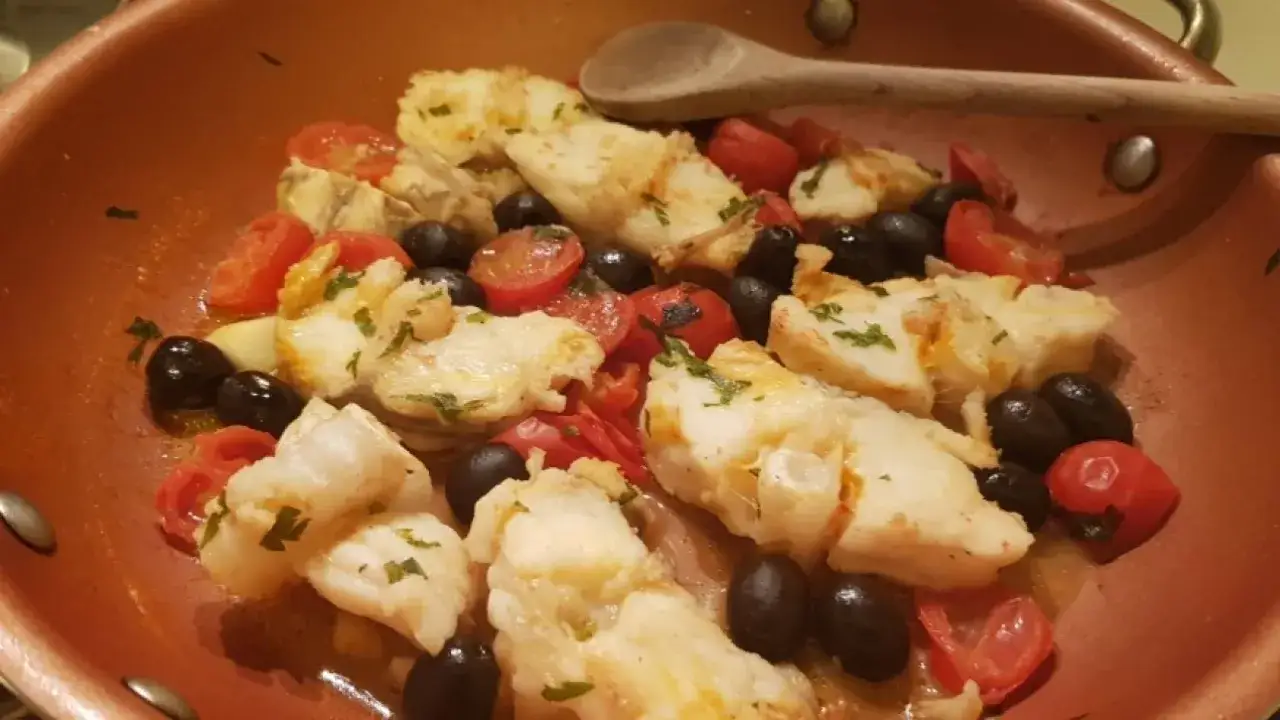Pezzi di rana pescatrice cotti in padella con pomodorini e olive nere. Un'idea per gustose rana pescatrice ricette.