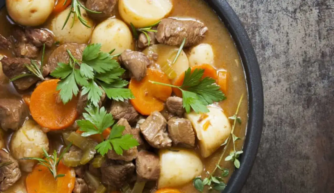 Un invitante spezzatino di manzo con patate, carote e erbe aromatiche, pronto per essere gustato.