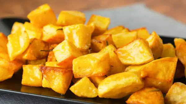 Un piatto invitante di patate al forno croccanti, dorate e saporite, pronte per essere gustate.
