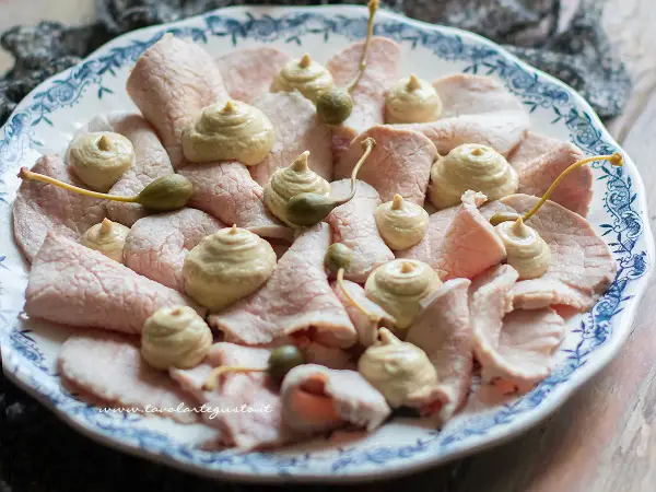 Vitello tonnato ricetta originale piemontese: fettine sottili di carne rosa, guarnite con salsa tonnata e capperi.