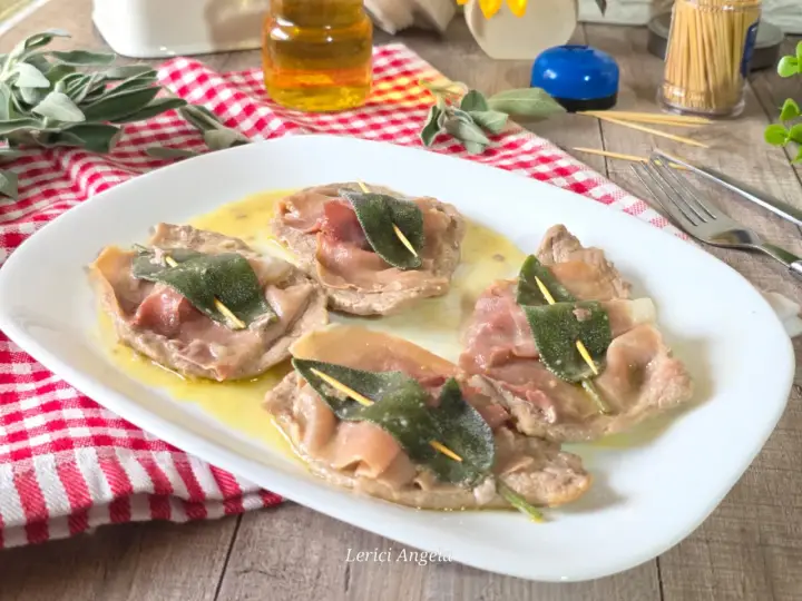 Saltimbocca alla romana su piatto bianco, con prosciutto crudo e salvia, su un tavolo di legno.