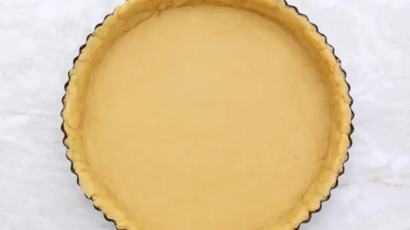 Base di pasta frolla senza glutine pronta per essere farcita.